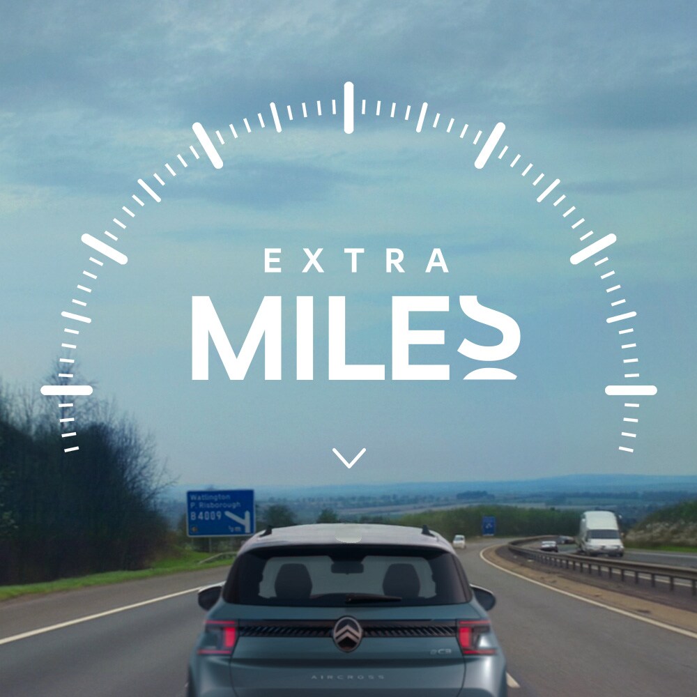 Rear view of a Citroën vehicle driving on a road, illustrating the Extra Miles initiative