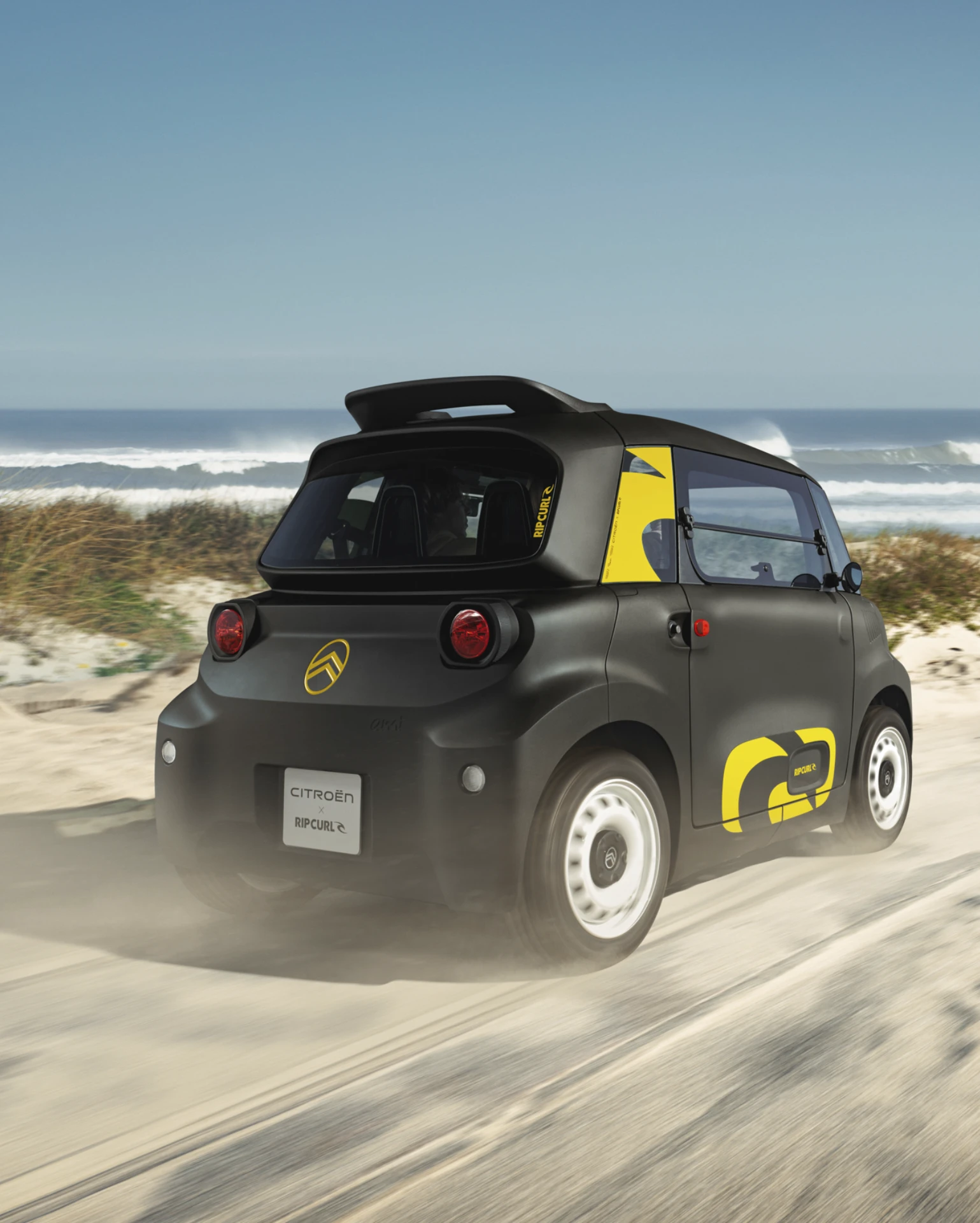 Vue arrière trois-quarts en conduite Citroën Ami x Rip Curl électrique sans permis, Citroën Ami conduite ludique pour voiture électrique urbaine